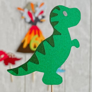 May include: Green felt dinosaur cutout with a white eye, ideal for a dinosaur-themed party or craft project.