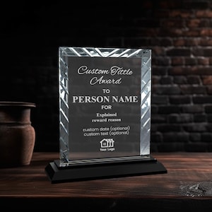 Puede incluir: Un premio de cristal transparente con una base negra. El premio tiene un patrón de diamante y el texto "Custom Tittle Award" y "PERSON NAME" está impreso en la parte delantera. El texto "Explained reward reason. custom date (optional) custom text (optional)" también está impreso en la parte delantera. Un icono de casa está impreso en la parte inferior con el texto "Your Logo".