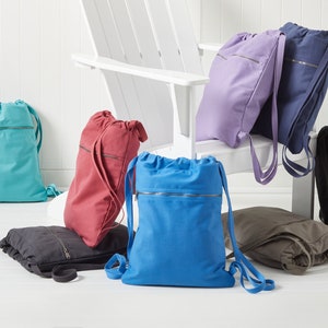 Puede incluir: Un conjunto de nueve mochilas de cord&oacute;n en varios colores, incluyendo turquesa, rojo, azul, morado, negro y gris. Las mochilas tienen un bolsillo con cremallera en la parte delantera y est&aacute;n hechas de un material similar al lienzo.