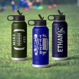May include: Three insulated water bottles with black lids and straws. One is olive green with "MIKE" and "#33" on it. The second is blue with "TYLER" and a football player graphic. The third is navy blue with "ETHAN" and a football helmet.