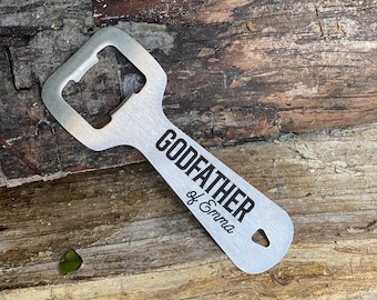 May include: Silver bottle opener with a black inscription that reads "GODFATHER of Emma".