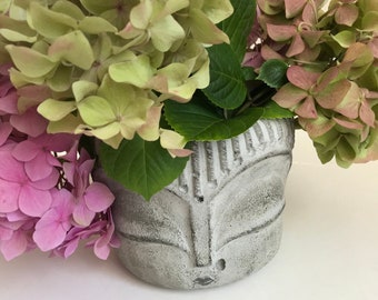 Jardinera de hormigón con cabeza de Buda