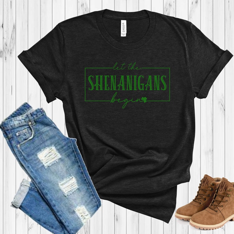 May include: A black t-shirt with a green graphic that says "Let the Shenanigans Begin" with a shamrock.