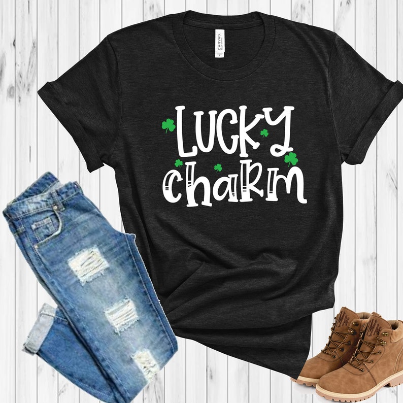 May include: Black t-shirt with white text that says "lucky charm" and green shamrock graphics.