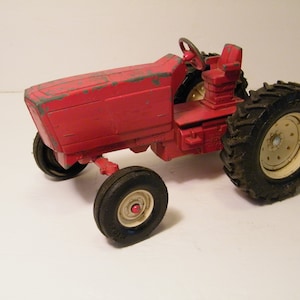 Red ERTL Steerable Die Cast Toy Tractor in USED condition, Vintage Collectible IH with lots of patina, stock 145, plastic wheels