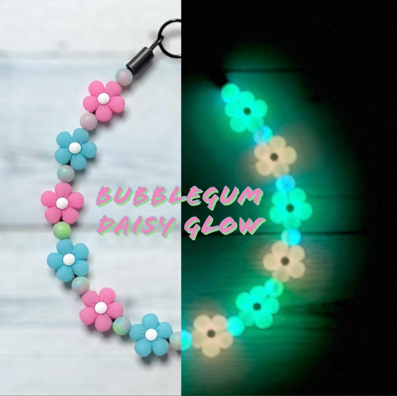 May include: A necklace with pink and blue daisy flower beads with white centres, and light pink and green beads. The text "BUBBLEGUM DAISY GLOW" is visible. The necklace glows in the dark.