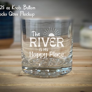May include: A clear glass with a textured bottom, featuring the text "The River is my Happy Place" with a sun graphic. The glass is 10.25 ounces.
