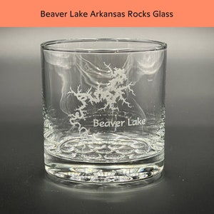 May include: A clear glass rocks glass with an etched design of Beaver Lake, Arkansas. The glass has a textured bottom.