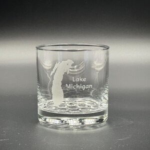 May include: A clear glass tumbler with a frosted etching of the outline of Lake Michigan and the text "Lake Michigan".