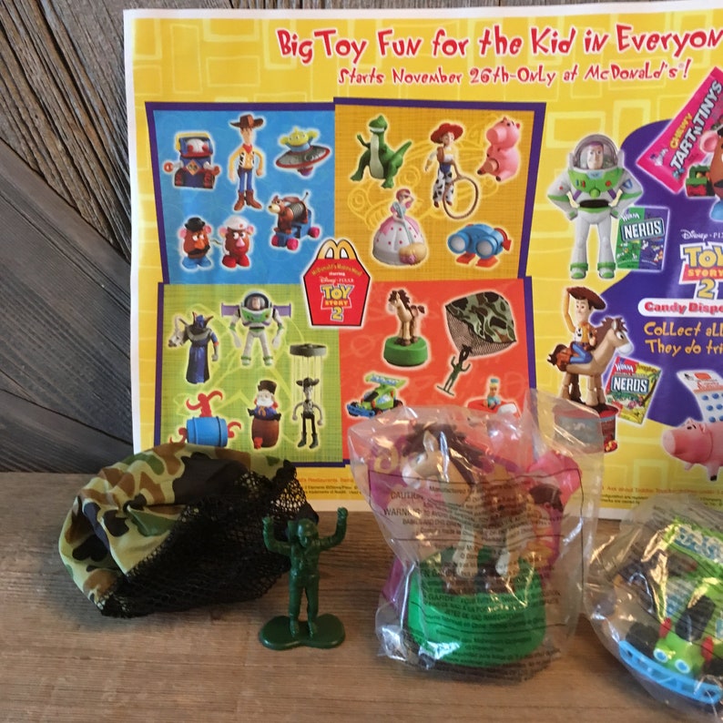 Pode incluir: Uma cole&ccedil;&atilde;o de brinquedos Happy Meal do Toy Story 2 do McDonald's. Os brinquedos incluem Woody, Buzz Lightyear, Jessie, Bullseye e muito mais. Os brinquedos s&atilde;o embalados em sacos de pl&aacute;stico transparentes com fundo verde e rosa. Os brinquedos s&atilde;o acompanhados por uma bolsa Happy Meal do McDonald's com o logotipo do Toy Story 2.