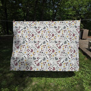May include: A light gray quilt featuring a repeating pattern of snowmen wearing red hats and scarves, red and white checkered hearts, yellow stars, and the text Let it snow in black script, all arranged across the fabric surface.