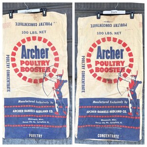 May include: Vintage Archer Poultry Booster sack. The beige sack features a large red and blue circular design with the text "Archer Poultry Booster." An illustration of an archer is in the center. The sack reads "100 LBS. NET" and "POULTRY CONCENTRATE."