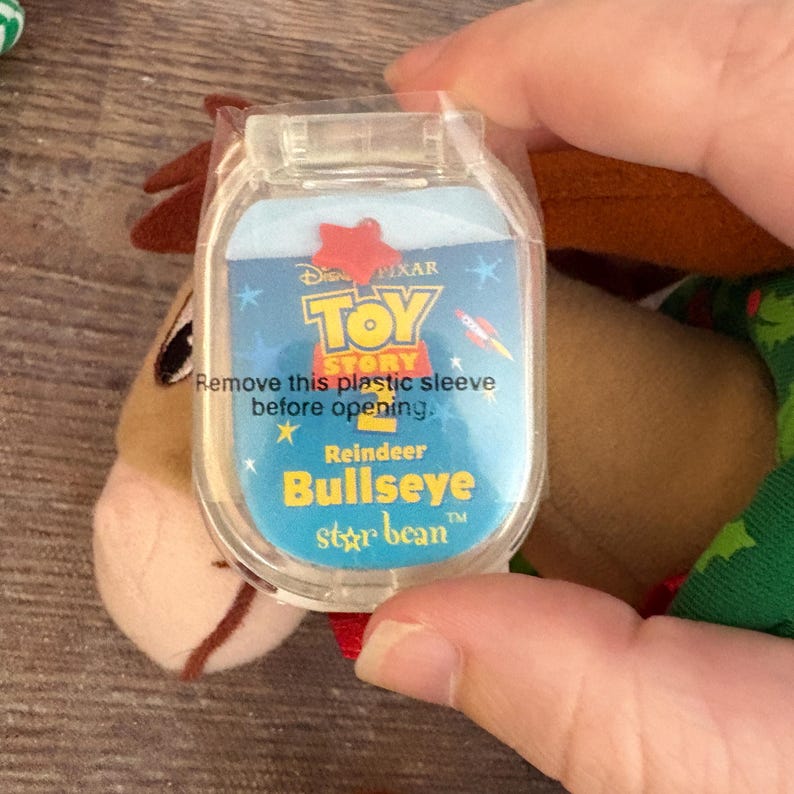 May include: A plush toy of the Toy Story character Bullseye, the reindeer. The toy is in a clear plastic sleeve with the Toy Story logo and the text "Remove this plastic sleeve before opening."