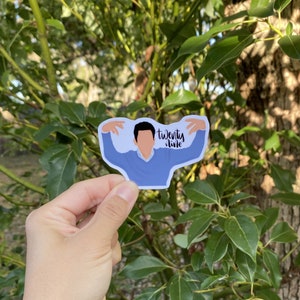 May include: A blue sticker with a cartoon illustration of a person with their arms outstretched and the text "twenty-five" written in black.