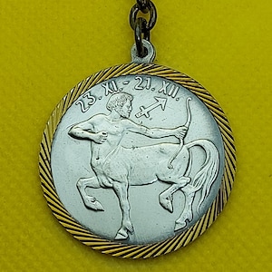 Symbol znaku zodiaku Strzelca, ikona horoskopu, stare zabytkowe metalowe breloki, klucz