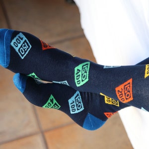 May include: A pair of dark blue socks with a colorful pattern of ISO numbers. The socks have a blue cuff.