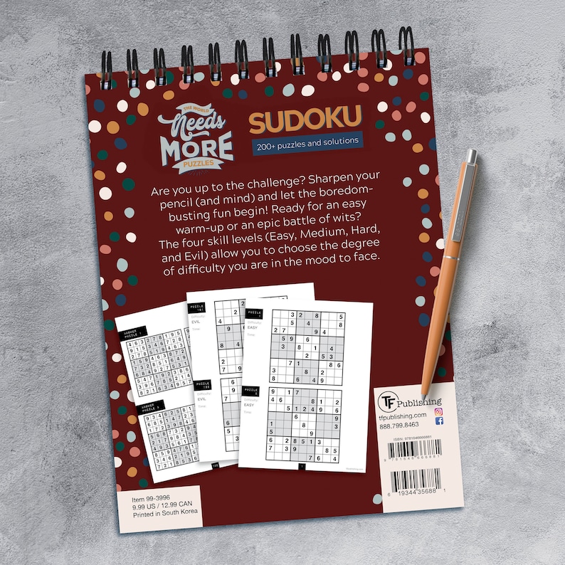 May include: A red and white spiral bound book with the title "Needs More Puzzles" and the word "Sudoku" in a white box. The book has a red background with white polka dots and features a sample Sudoku puzzle on the cover. The book is &pound;7.99 and printed in South Korea.