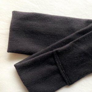 Puede incluir: Una diadema negra doblada de tela suave. La diadema es de color liso y parece estar hecha de un material el&aacute;stico. La diadema est&aacute; dise&ntilde;ada para usarse en la cabeza para mantener el cabello fuera de la cara.