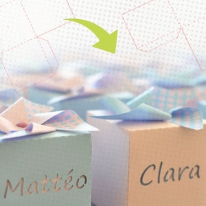 May include: Two small, decorated boxes with the names "Matt&eacute;o" and "Clara" on them. The boxes are shaped like windmills and are made of paper. The boxes are part of a set of printable templates for creating your own windmills.