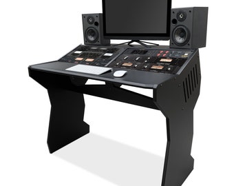 May include: Black studio desk with a computer monitor, keyboard, mouse, and two black speakers. The desk has a black surface with a control panel and a black frame with a unique design.