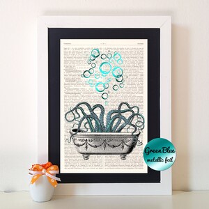 Op de afbeelding: Ingelijste kunstprint met een illustratie van een octopus in een badkuip. De octopus is blauwgroen, met blauwgroene bellen boven de kuip. Het kunstwerk staat tegen een achtergrond van een vintage woordenboekpagina.