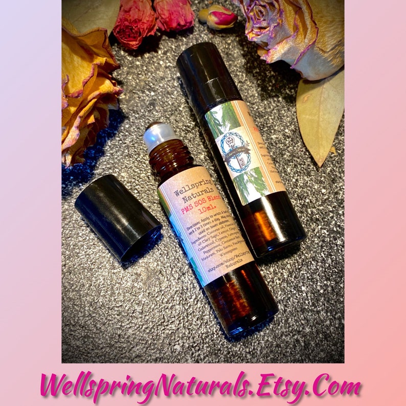 May include: Two brown glass roller bottles with black caps. The bottles are labeled "Wellspring Naturals PMS SOS Blend 10mL."