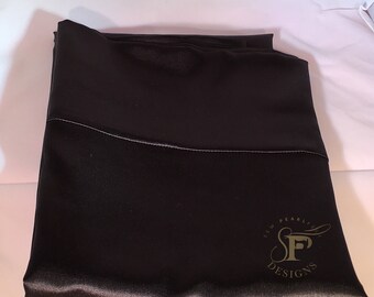 Puede incluir: Una funda de almohada de satén negro con un logotipo dorado que dice "Sew Pearly Designs" y una letra estilizada "F" en el centro.