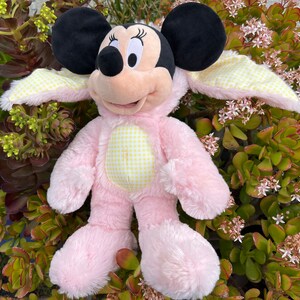 May include: Pink plush Mickey Mouse dressed in a yellow and white gingham bunny costume with long floppy ears.