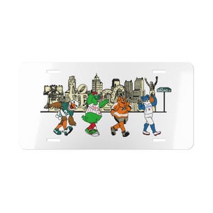 May include: White license plate featuring cartoon mascots of Philadelphia sports teams walking in front of a city skyline. The mascots are in their team colors, with the word "Broad St" on a street sign.