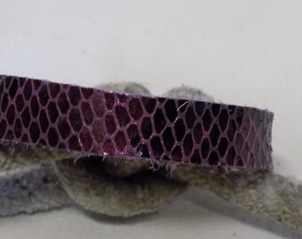 May include: A close-up of a purple snakeskin leather strap with a textured pattern. The strap is folded in half and appears to be part of a larger piece of leather.