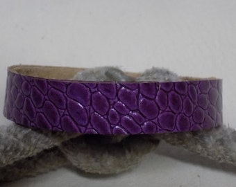 May include: A purple leather bracelet with a crocodile skin pattern.