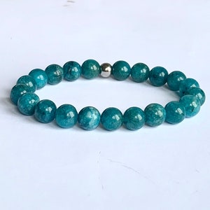 May include: A teal blue gemstone bracelet with a silver bead accent.