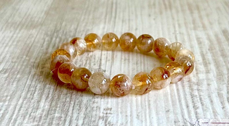 May include: A bracelet made of round, translucent, golden-brown beads with a light brown, cloudy appearance.