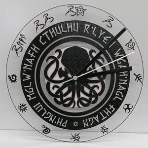 May include: A black and white clock with a circular design featuring a stylized octopus and the text "PH'NGlui Mglw'nafh Cthulhu R'lyeh Wgah'nagl fhtagn".