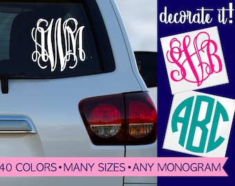 May include: A white vinyl monogram decal applied to a car rear window, with additional pink script and teal block letter monogram stickers shown on the side. The text "decorate it!" and "40 COLORS • MANY SIZES • ANY MONOGRAM" is visible.