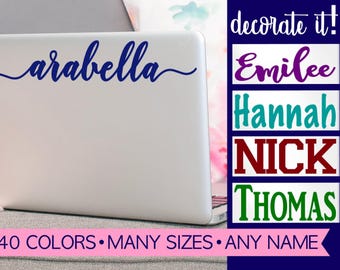 May include: A silver laptop featuring a custom dark blue vinyl name decal that reads arabella in a cursive script. To the right, a list displays names Emilee, Hannah, NICK, and THOMAS in various colors. Text at the bottom reads 40 COLORS MANY SIZES ANY NAME.