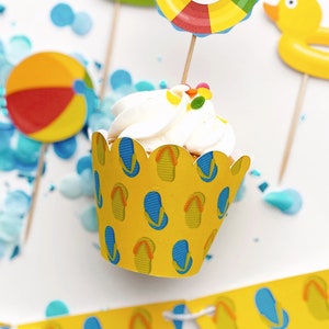 May include: A yellow cupcake liner with a flip-flop pattern. The cupcake liner is filled with white frosting and colorful sprinkles. The cupcake is surrounded by blue and yellow confetti.