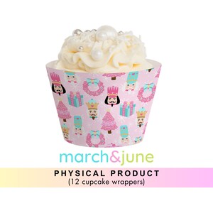 May include: Pink cupcake wrappers with a Nutcracker theme. The wrappers feature a repeating pattern of nutcrackers, Christmas trees, presents, and wreaths. The text "march&june" is printed on the bottom of the wrappers.  PHYSICAL PRODUCT (12 cupcake wrappers)