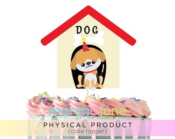 May include: A cake topper featuring a cartoon dog inside a doghouse with the word "DOG" above. The dog is wearing a party hat. The cake has pink frosting and sprinkles, with the text "march & june" and "PHYSICAL PRODUCT (cake topper)" below.