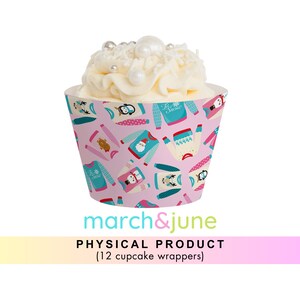 Könnte beinhalten: Rosa Cupcake-Verpackungen mit einem Muster aus bunten Weihnachtspullovern, Pinguinen, Rentieren und Schneemännern. Der Text "Let It Snow" befindet sich auf einigen der Pullover. Die Verpackungen sind für 12 Cupcakes.