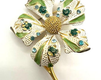 Broche vintage BSK em tom dourado, esmalte branco e verde, flor com strass azul.