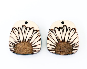 May include: Two wooden earrings with a brown and white daisy design.