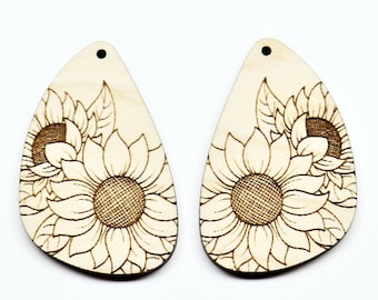 May include: A pair of wooden earrings with a laser-etched sunflower design. The earrings are shaped like teardrops and have a natural wood finish.
