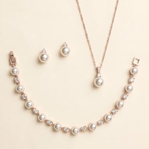 a collection of pearl jewelry, including a necklace, earrings, and a bracelet, all featuring a delicate and elegant design.