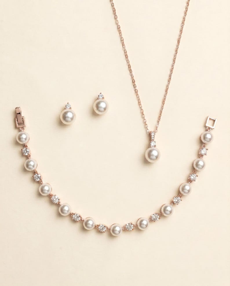 a collection of pearl jewelry, including a necklace, earrings, and a bracelet, all featuring a delicate and elegant design.