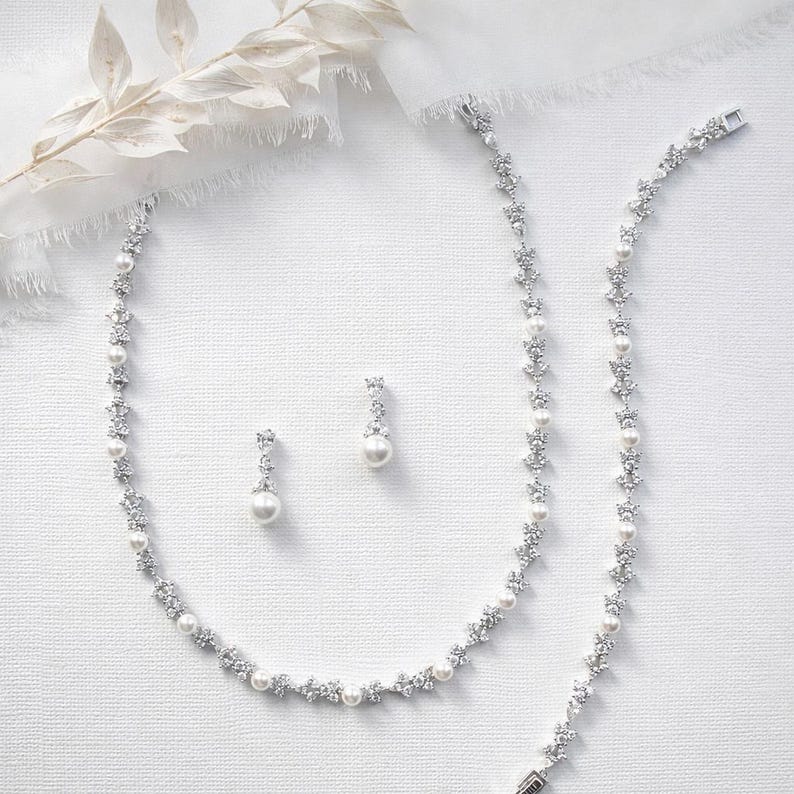 a collection of elegant jewelry pieces, including a necklace, earrings, and a bracelet, all adorned with sparkling diamonds and pearls.