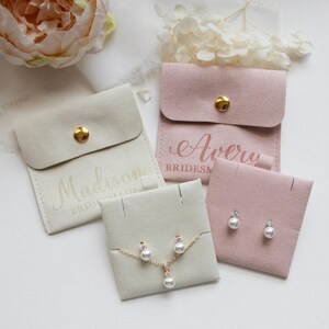 a collection of jewelry items, including earrings and a necklace, presented in various cases and bags.