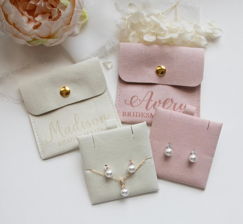 a collection of jewelry items, including earrings and a necklace, presented in various cases and bags.
