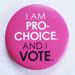 May include: Pink button with the text "I am pro-choice. And I vote."