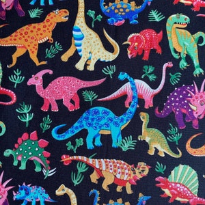 May include: A black background is covered with a colorful pattern of various dinosaurs. The dinosaurs are in shades of orange, yellow, pink, blue, green, and purple. Some have spots, stripes, or other patterns. Green plant-like shapes are scattered throughout.